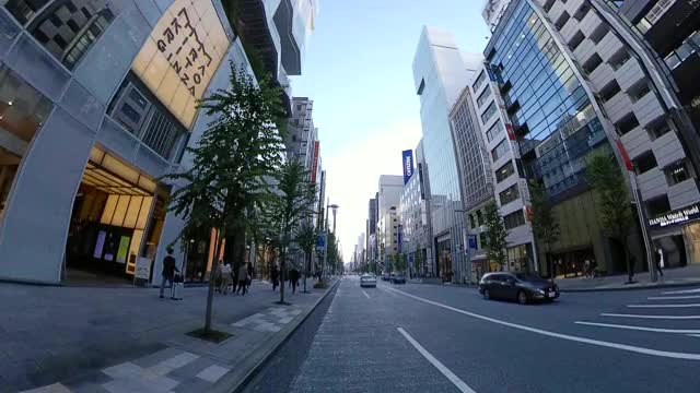 POV在城市里骑自行车。黄昏时分骑自行车穿过银座。日本东京。交付服务的概念。行动相机拍摄。