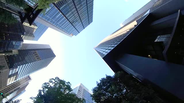 在城市里骑自行车。抬头看看四周。骑自行车穿过城市，日本东京。行动相机拍摄。