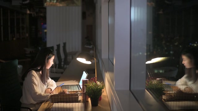 詳情圖-亞洲華裔女白領(lǐng)在辦公室工作到深夜獨(dú)自趕財(cái)務(wù)報(bào)告