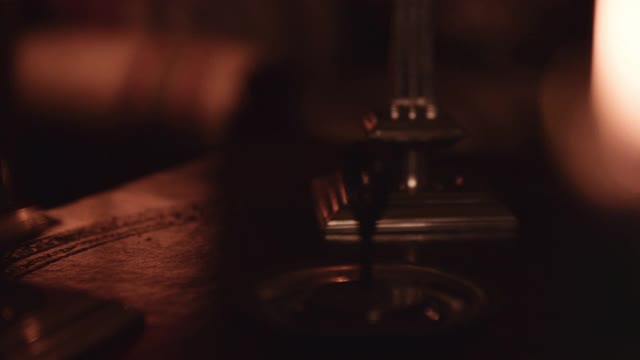 羽毛笔和墨水在烛光下。