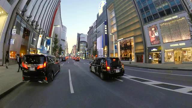 POV在城市里骑自行车。黄昏时分骑自行车穿过银座。日本东京。交付服务的概念。行动相机拍摄。
