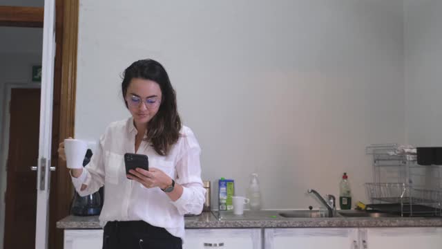 一个忙着玩手机的女人把咖啡洒了一身
