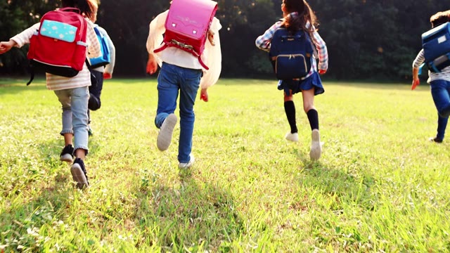 详情图-一群小学生在草地上跑步