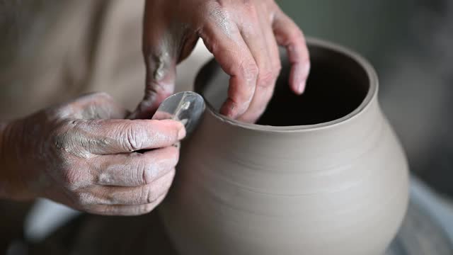 亚洲华人高级泥塑艺术家在他的工作室与纺织陶轮工作