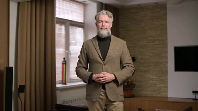 一位灰白头发、留着胡子的成年男子高兴地张开双臂，准备拥抱