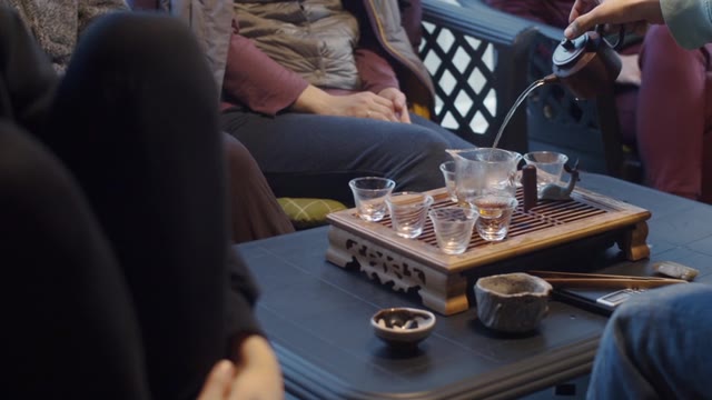 详情图-手持视频拍摄的无脸男子将水倒进茶壶的慢动作。一个不知名的人在中国仪式上用玻璃器皿泡茶。茶具设备文化