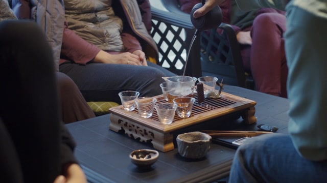 详情图-手持视频拍摄的无脸男子将水倒进茶壶的慢动作。一个不知名的人在中国仪式上用玻璃器皿泡茶。茶具设备文化