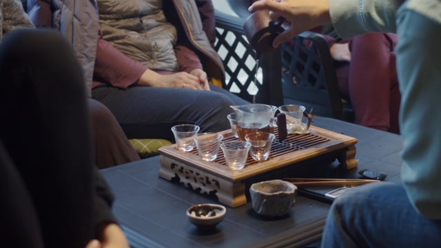 详情图-手持视频拍摄的无脸男子将水倒进茶壶的慢动作。一个不知名的人在中国仪式上用玻璃器皿泡茶。茶具设备文化