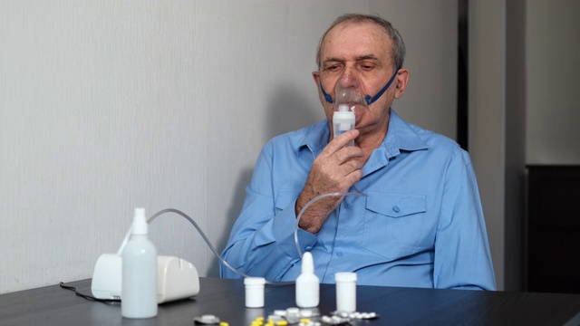 使用喷雾器进行吸入的年长男子