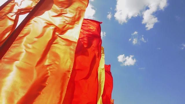 詳情圖-在藍(lán)天的慢鏡頭背景下，旗桿上的旗幟在陽(yáng)光明媚的日子里顫抖著