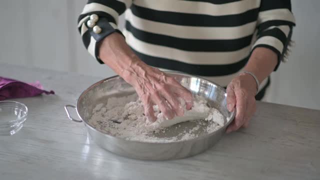 中国一对老年夫妇为春节团圆饭准备中国食物“汤圆”糯米团