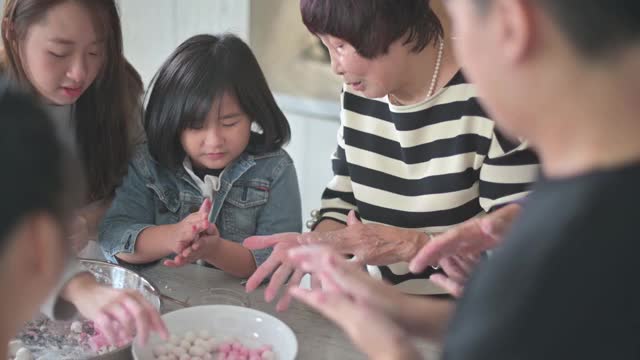中国的老年人家庭为春节团圆饭准备中国食物“汤圆”糯米团