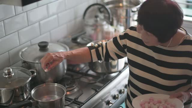 中国老年妇女兄弟姐妹准备中国食物“汤圆”糯米团为中国新年团圆饭