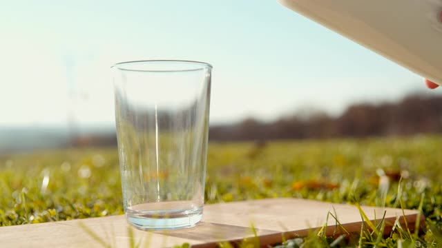 在一个阳光明媚的日子往杯子里倒牛奶