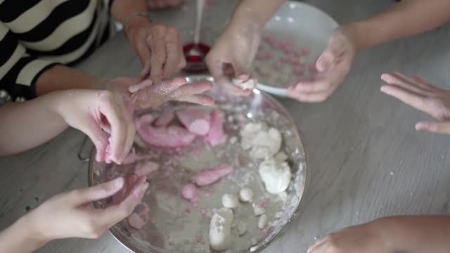 亚洲华人家庭制作汤圆为中国新年做准备。红白相间的粽子是中国的传统食物，用于农历新年、冬季的节日。