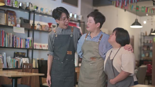 亚洲咖啡馆唐氏综合症残疾员工和老板在咖啡馆愉快地相处时间