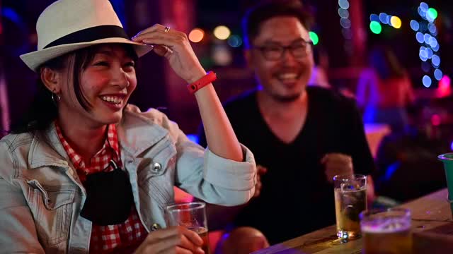 亚洲夫妇在酒吧享受晚间饮料的慢镜头