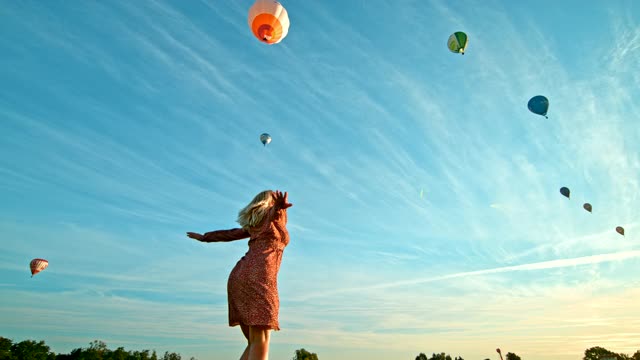 超級慢動作女人在熱氣球前的地面上旋轉(zhuǎn)