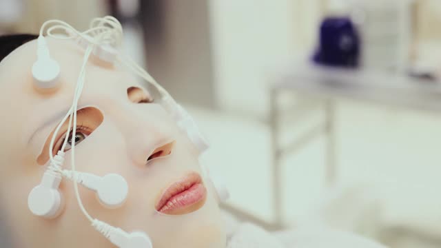 使用振動面罩進行面部按摩。特寫鏡頭。