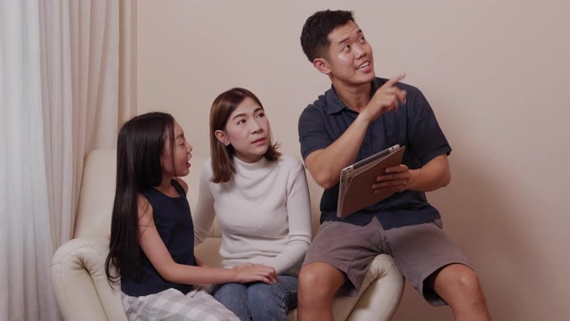 詳情圖-亞洲快樂的父母和漂亮的女兒在客廳里一起使用平板電腦享受家庭時光。