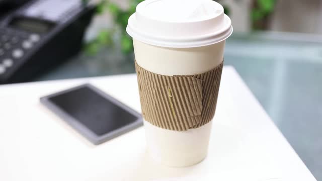 一杯咖啡，把手机放在笔记本电脑上。