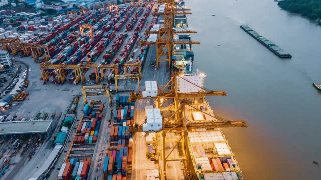 Hyperlapse / Timelapse无人机空中超滑运输工作新冠肺炎期间物流技术业务危机商务电子商务进出口运输集装箱货轮堆垛货物在船厂南侧工作吊车桥