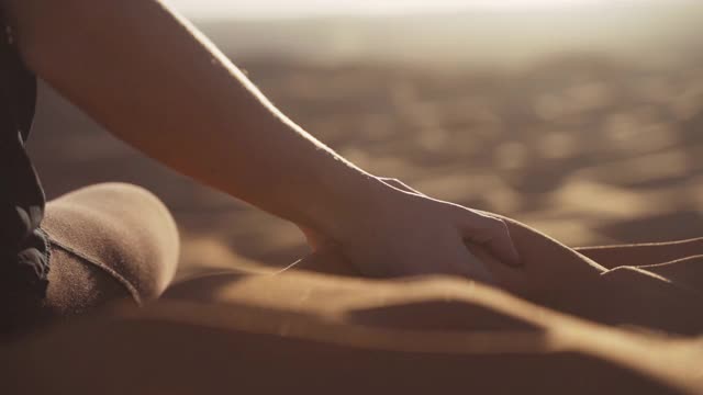 女人的手倒沙漠的沙子