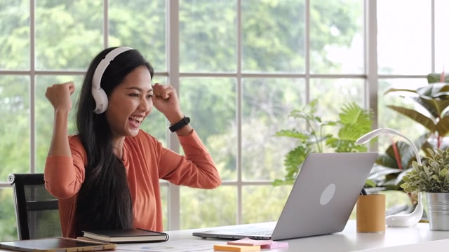 详情图-快乐的亚洲商务女性在家工作得到好消息时，与同事视频电话会议