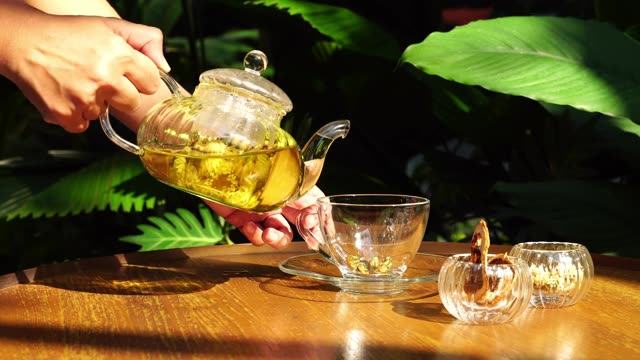 詳情圖-用手把茶倒在有陽光的桌子上