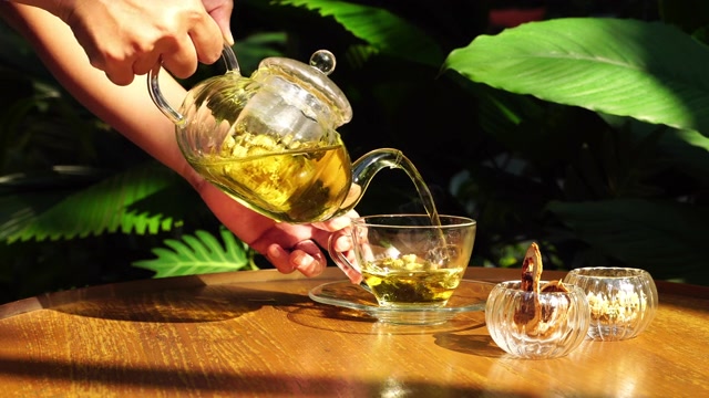 詳情圖-用手把茶倒在有陽光的桌子上