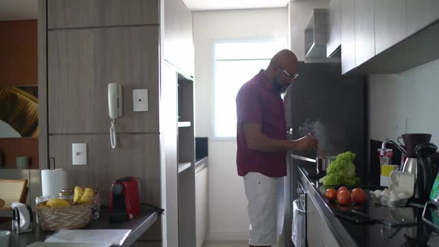 成熟的男人一边在家做饭一边跳舞