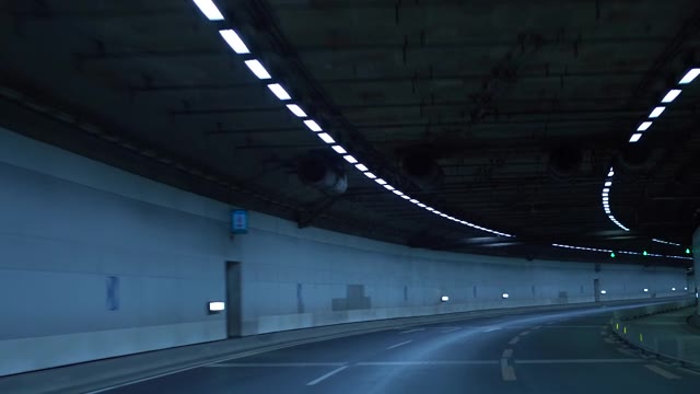 詳情圖-一輛車在夜間行駛在高速公路的隧道里