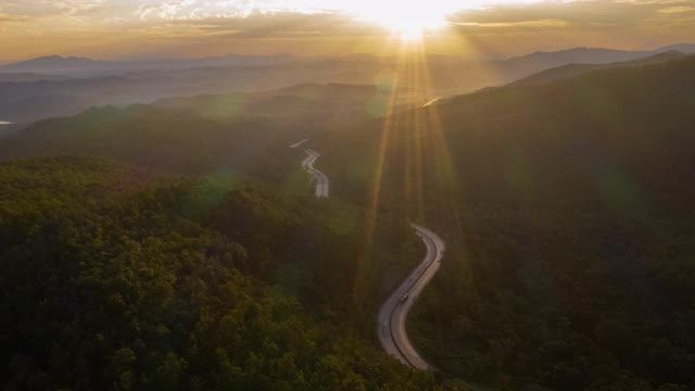 在日出中蜿蜒的道路山谷的超陷