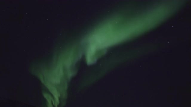 北极光在夜空中群山上空的剪影