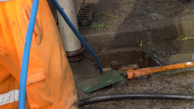 下水道工人试图疏通下水道时，水冒了出来