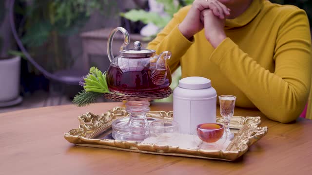 女子将茶从玻璃壶倒入杯中，茶道概念