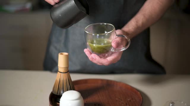 男人用牛奶泡制作抹茶绿茶拿铁