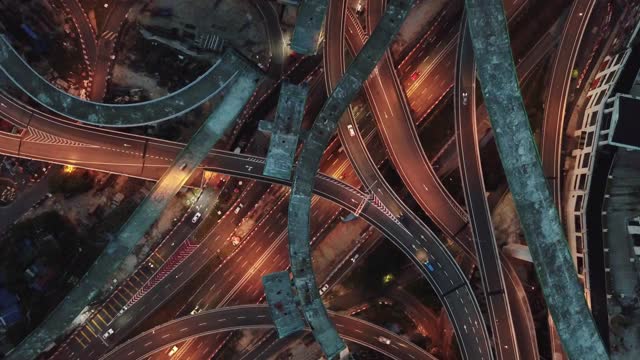 无人机直接俯瞰城市夜景与高架公路桥交叉路口