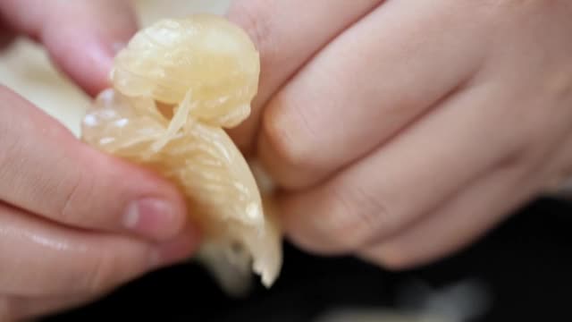 男孩在家为家人削柚子，慢镜头。