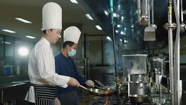 两个厨师在厨房生火做饭
