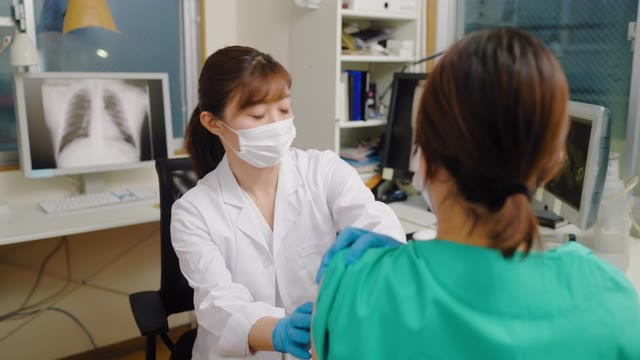 详情图-女医务工作者在医生办公室接种疫苗