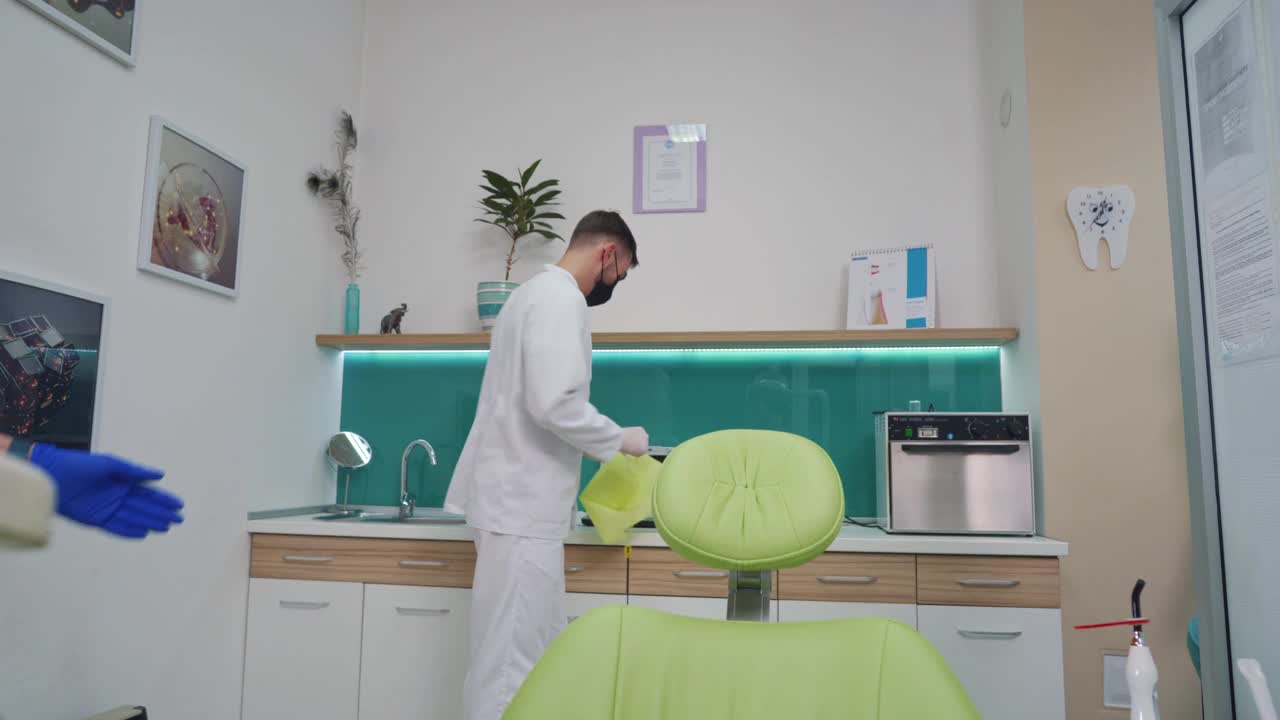 牙科医生在一个十几岁的病人开始看牙医之前给他敷上防护布