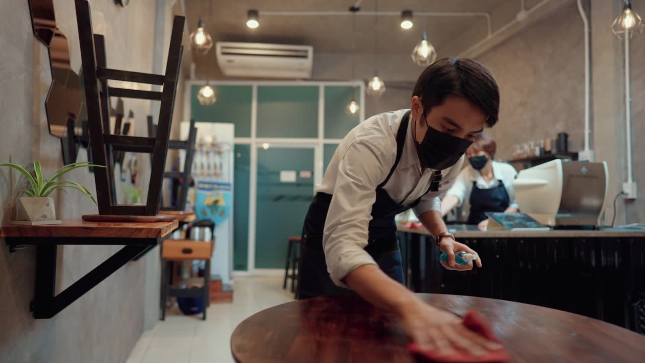 詳情圖-一對夫婦的老板戴著外科口罩在一個封閉的咖啡館里。