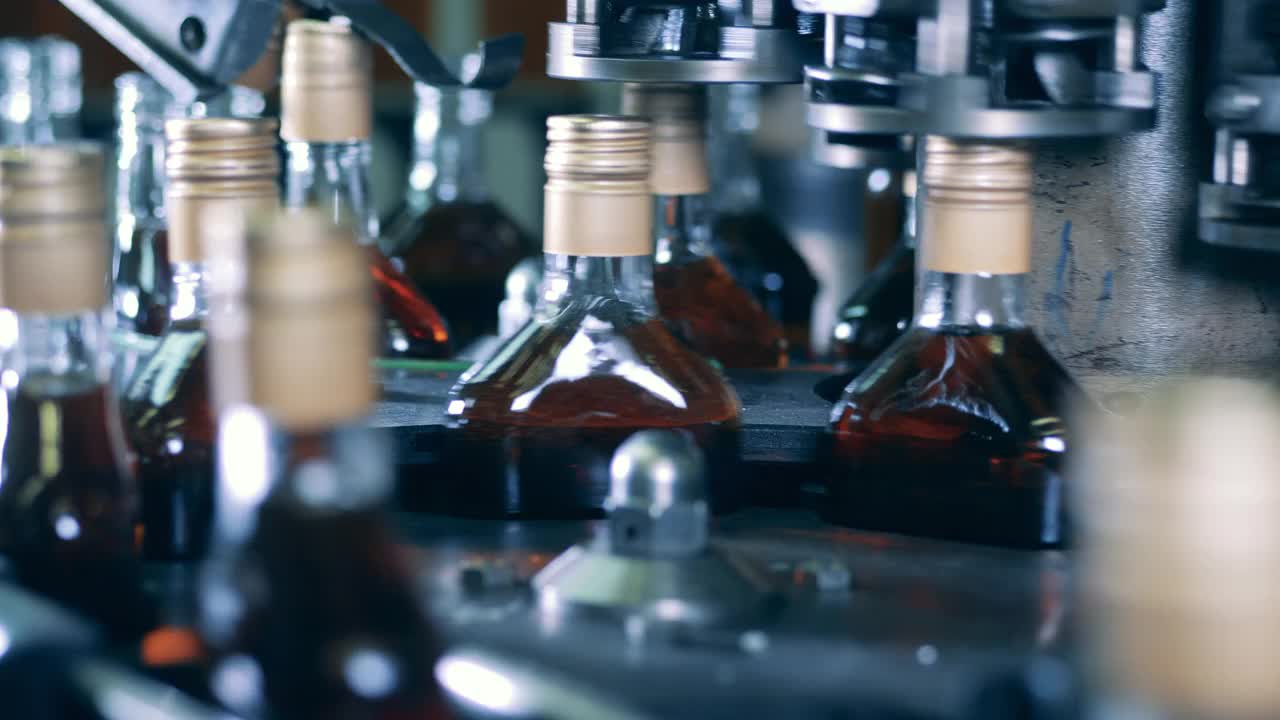 酒瓶的瓶盖由工厂的传送带密封