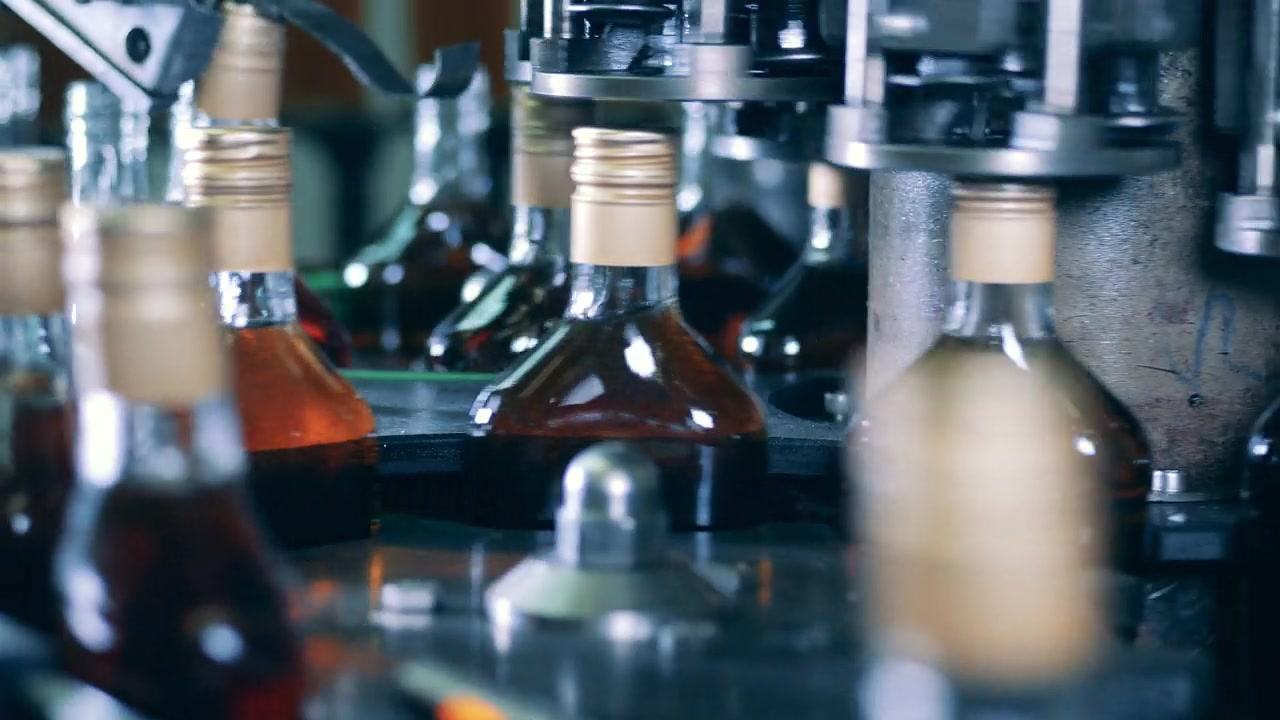 详情图-酒瓶的瓶盖由工厂的传送带密封