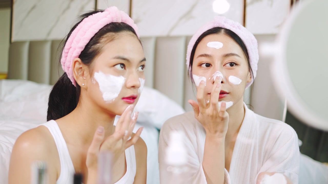 详情图-亚洲两个年轻的女性放松水疗在家里一边笑一边放松，微笑的女孩朋友有乐趣。居家。年轻女子在脸上敷面膜。水疗中心提供各种健康治疗。