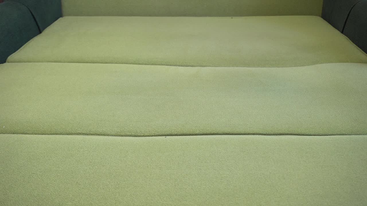用吸尘器除尘。年轻女子在打扫房间里的沙发时用吸尘器。十几岁的女孩打扫她的客厅，并帮助她的母亲。