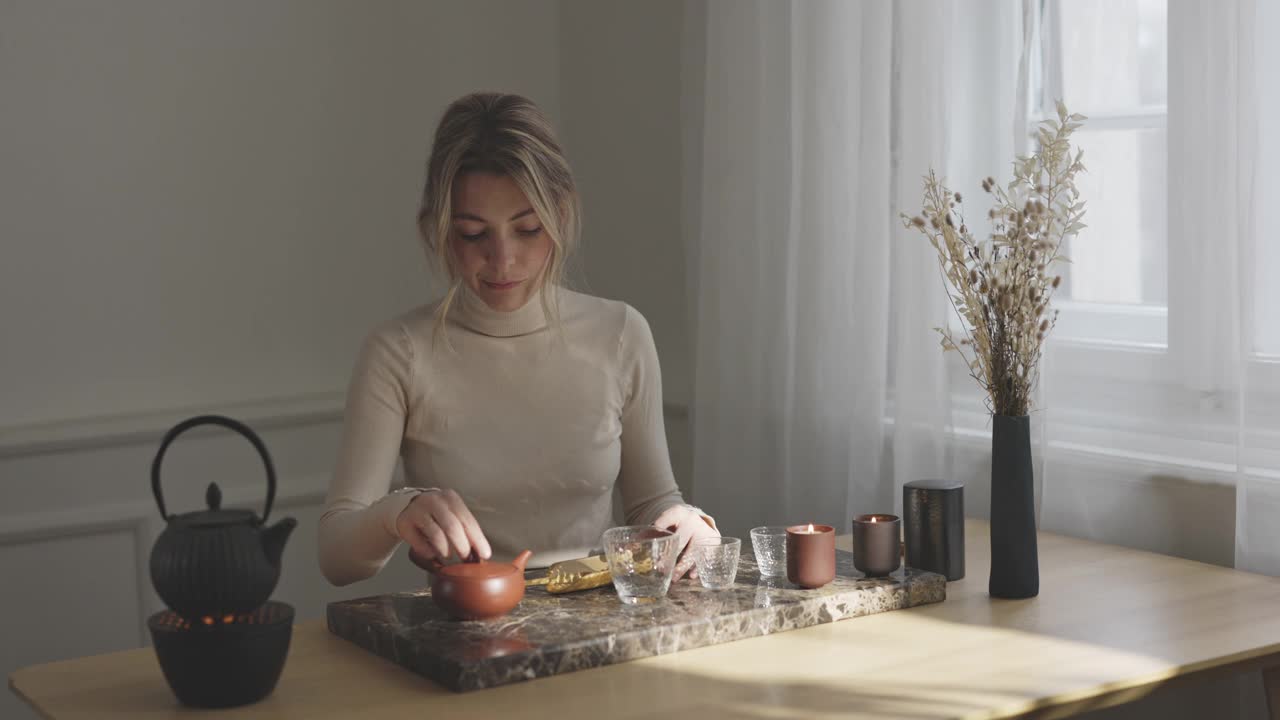 传统泡茶:美丽的年轻女子在家泡茶
