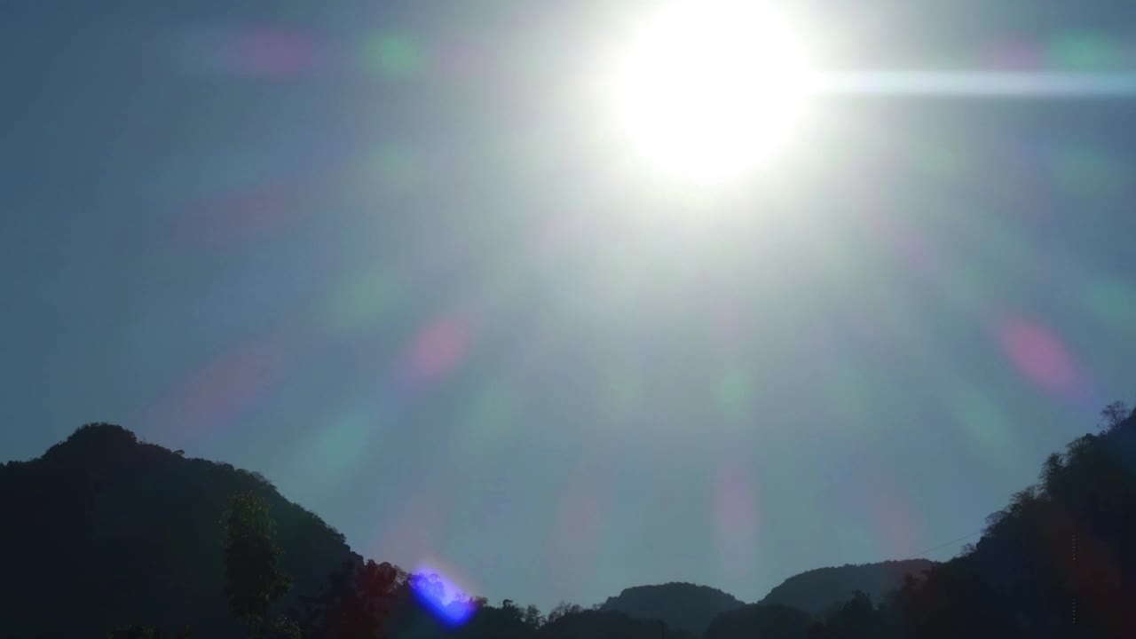 美丽的日落与太阳光线和焦镜头耀斑在晴朗的蓝天