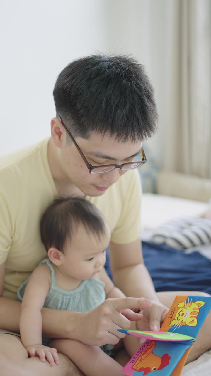 详情图-垂直亚洲年轻的父亲阅读儿童书籍与他的女儿